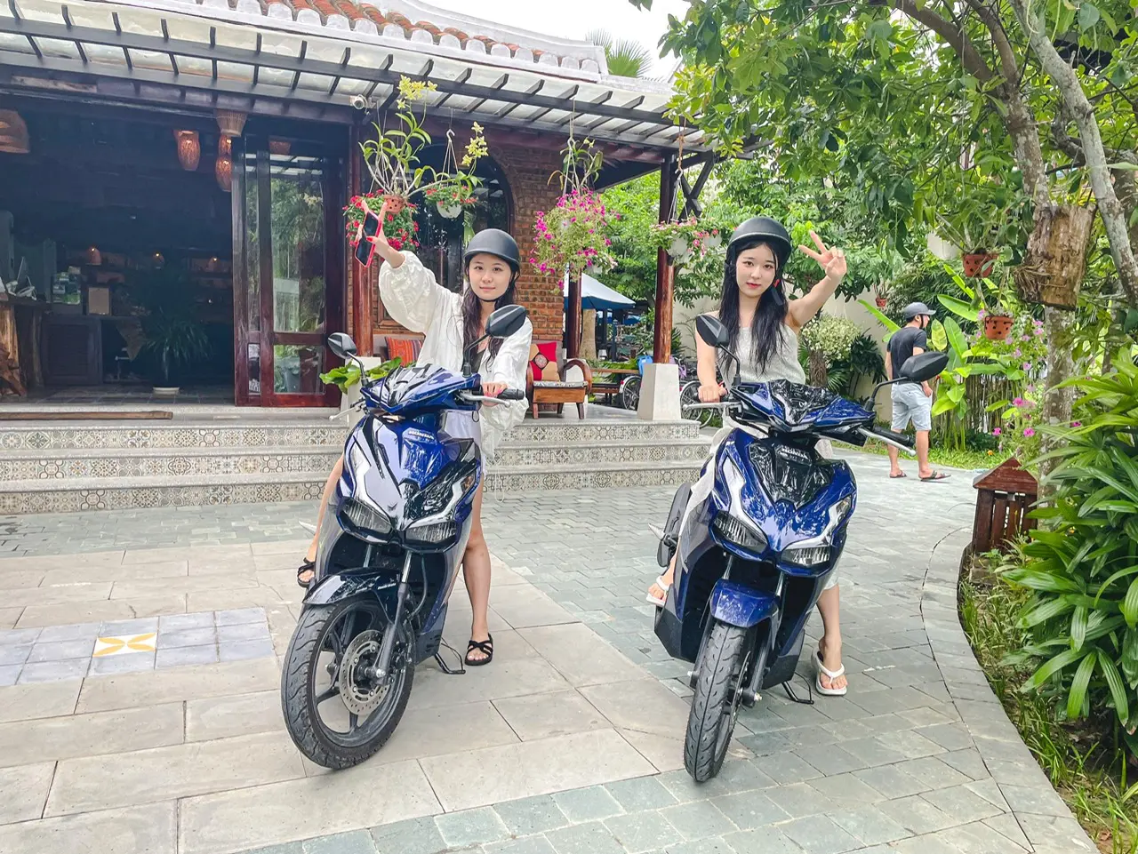 Tourists enjoying a scenic ride on scooters through the charming streets of hoi an, highlighting the convenience of anh khoa hoi an scooter rental.