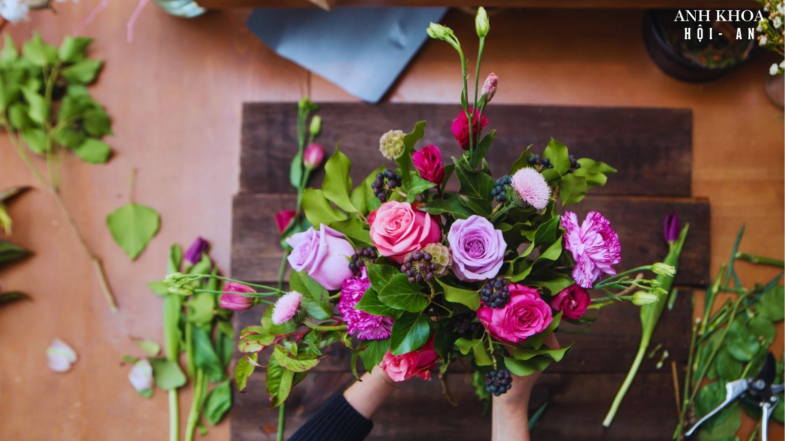 Florist arranging a pink and purple rose bouquet at Anh Khoa flower workshop in Hoi An