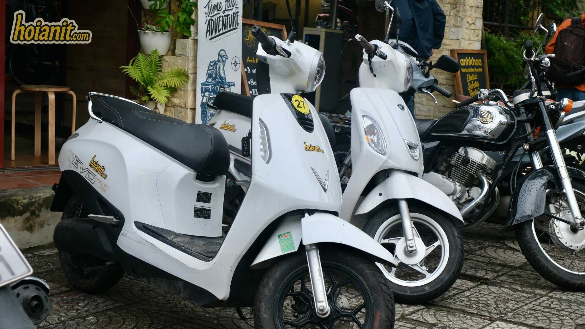White 50cc scooters lined up outside a rental shop in Hoi An