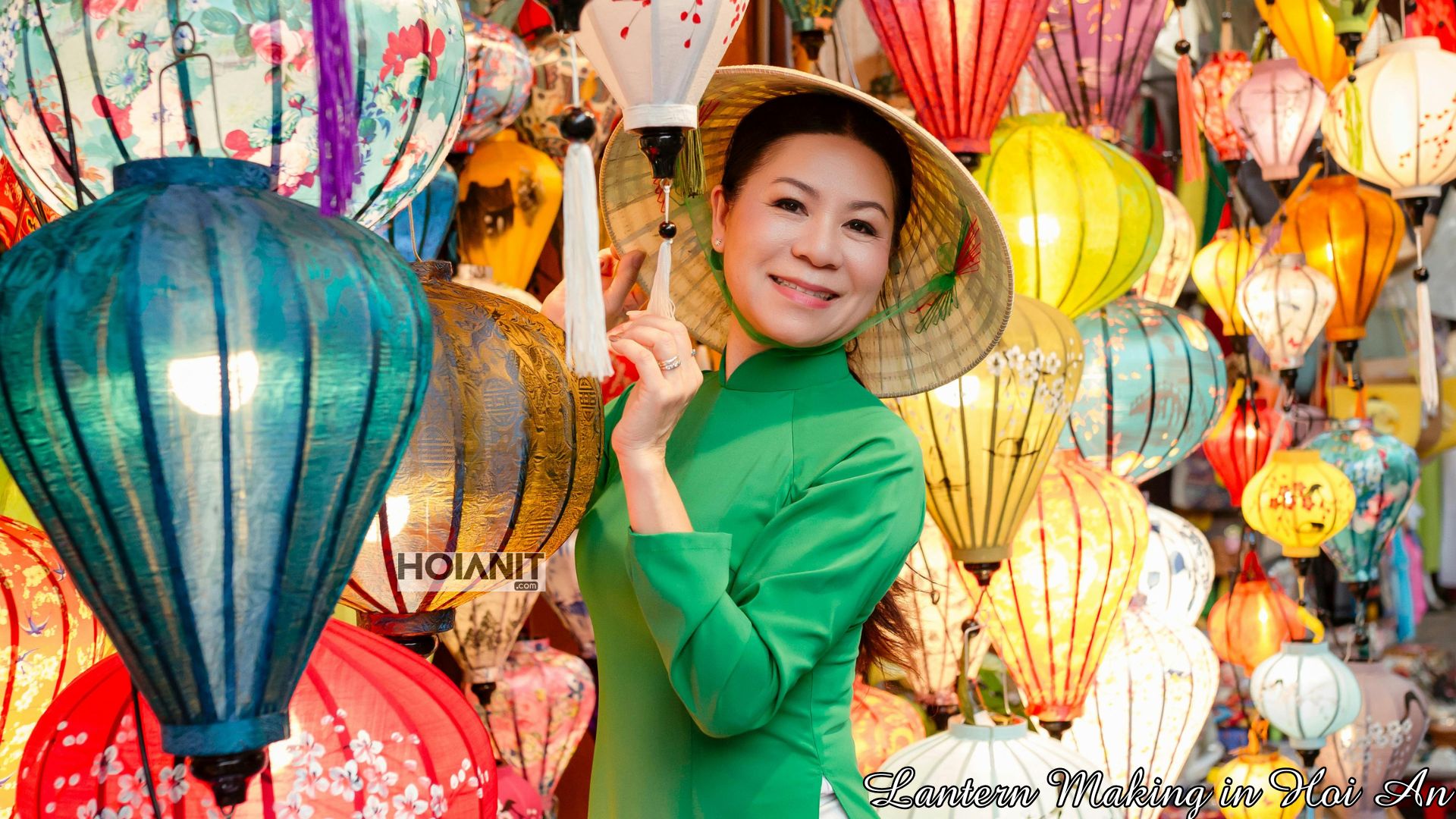 Woman in ao dai holding a finished silk lantern at a Hoi An lantern making class