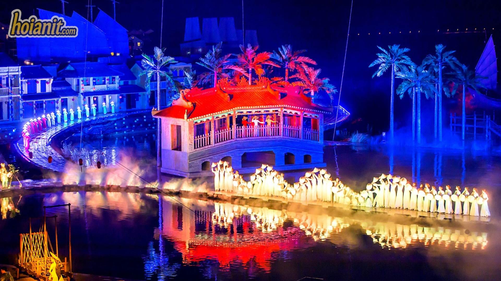 Performers with lanterns reflected in the water during the Hoi An Memories Show