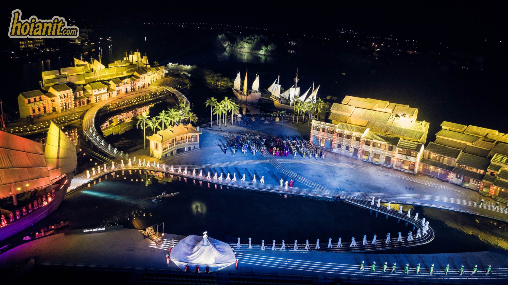 Aerial view of the Hoi An Memories Show stage at night with hundreds of performers on the water