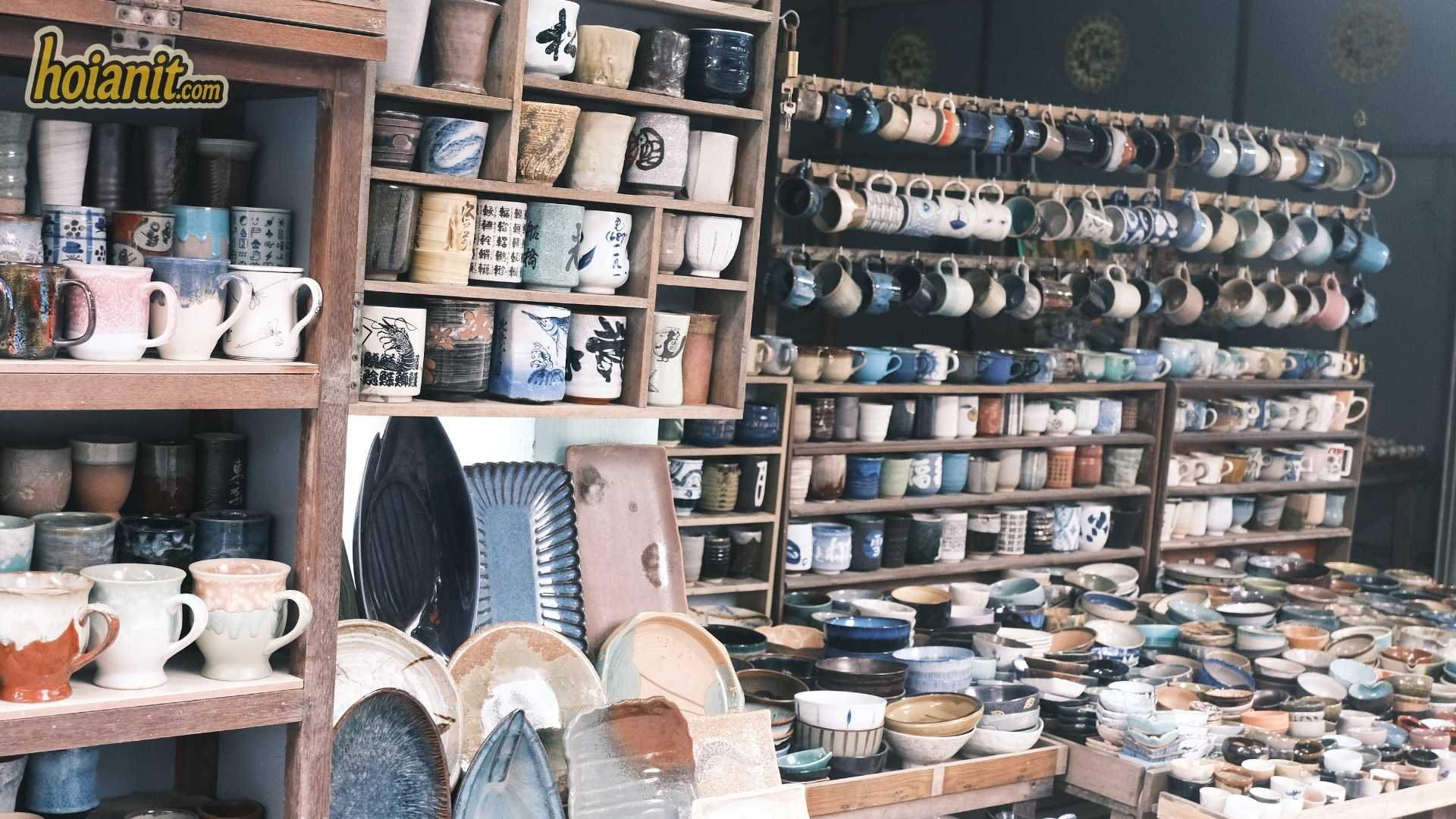 Shelves of glazed cups and bowls in a Thanh Ha pottery shop near Hoi An