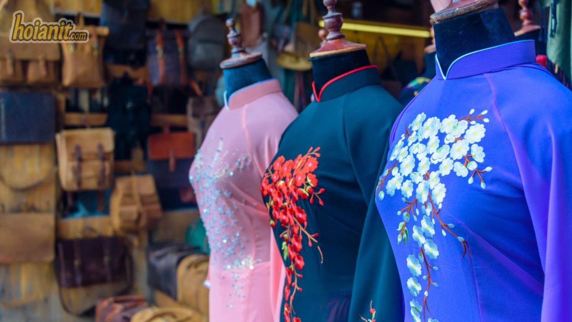 Busy tailor street in Hoi An Ancient Town with shopfronts displaying sample garments