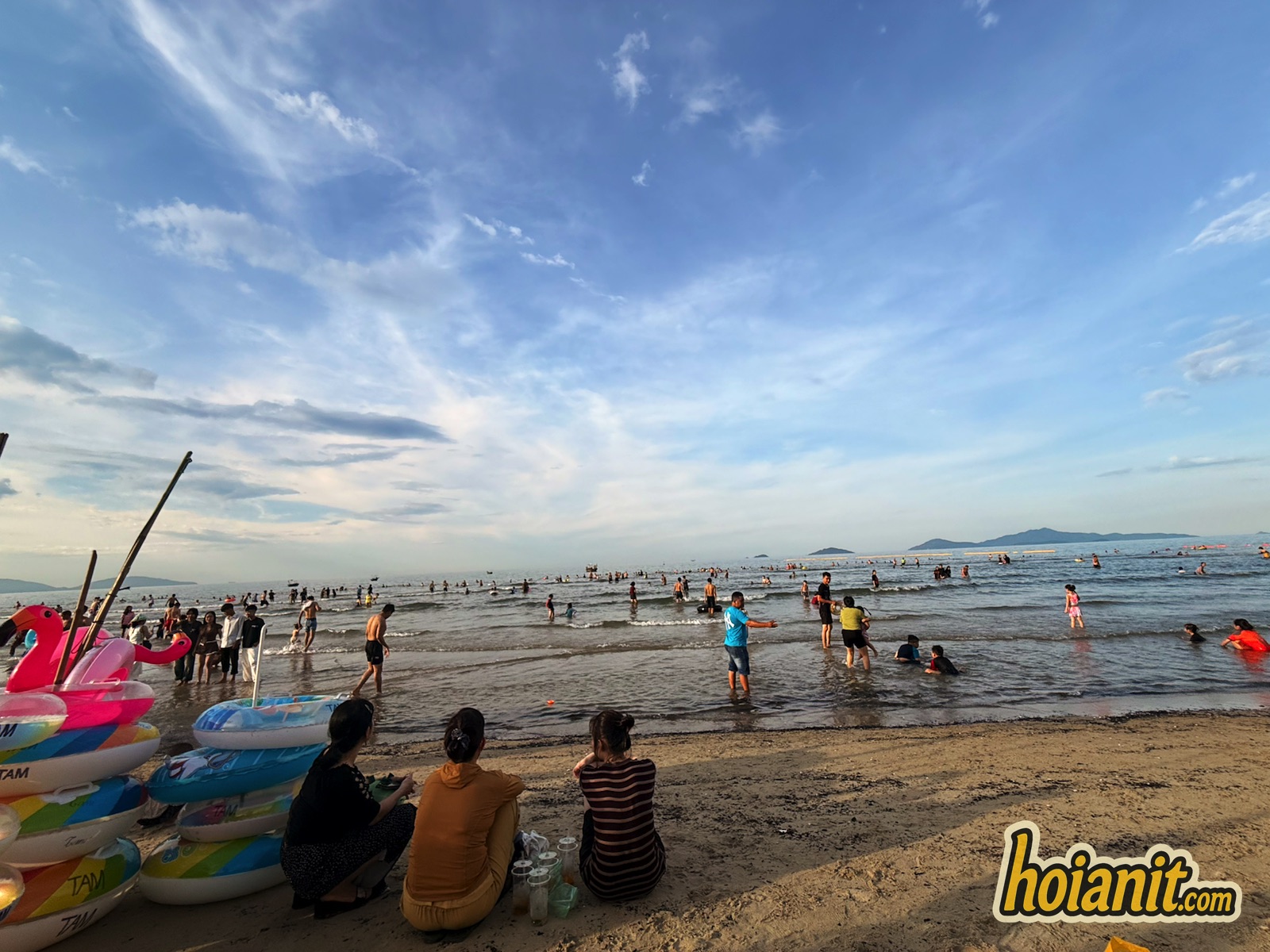 Crowds swimming at An Bang Beach Hoi An on a clear afternoon