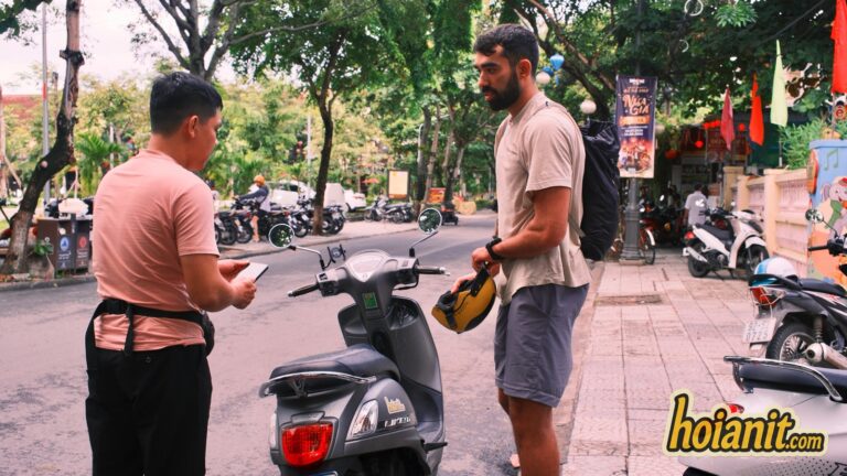 Anh Khoa staff handing over a rental scooter to a customer in Hoi An