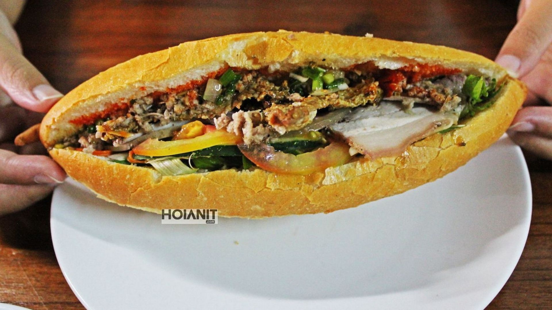 Ổ bánh mì Hội An cắt mở với pate, thịt, rau thơm và hành phi