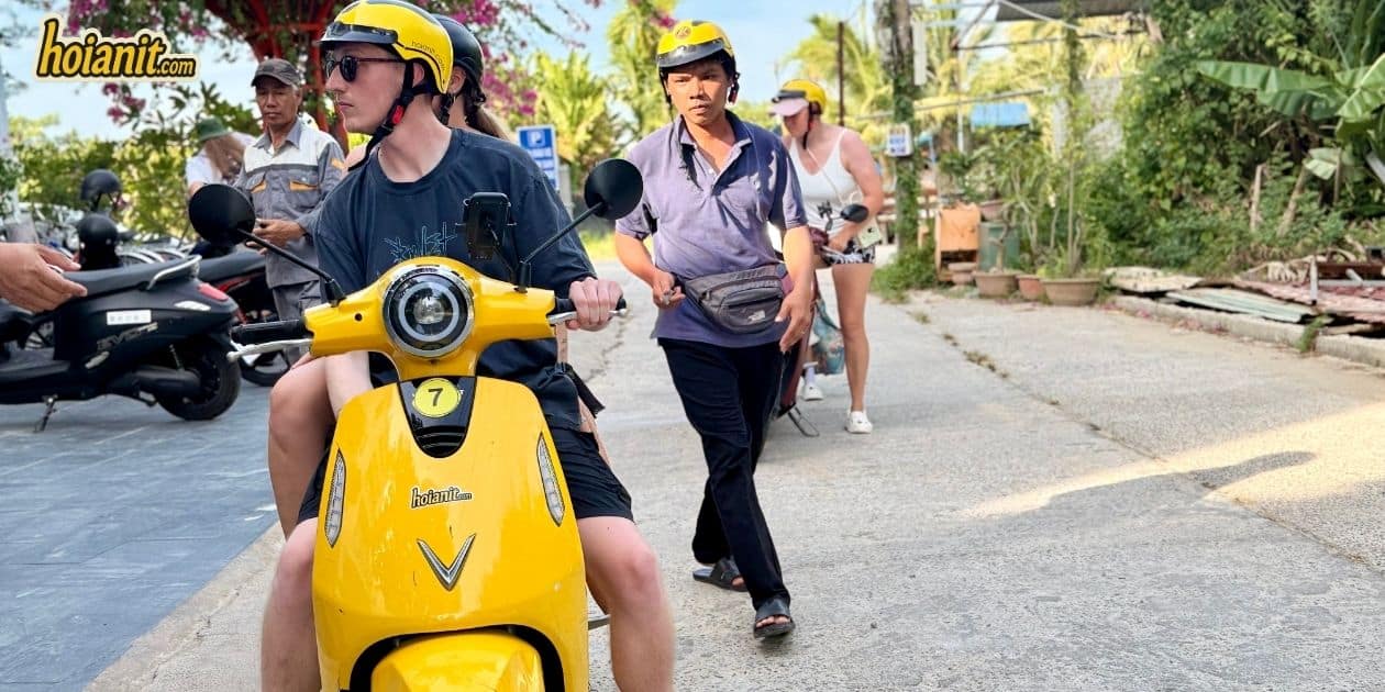 Anh Khoa staff handing over a scooter before a ride around Hoi An