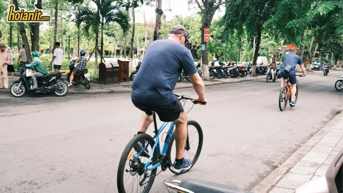 Riders on rental bicycles along a quiet street in Hoi An