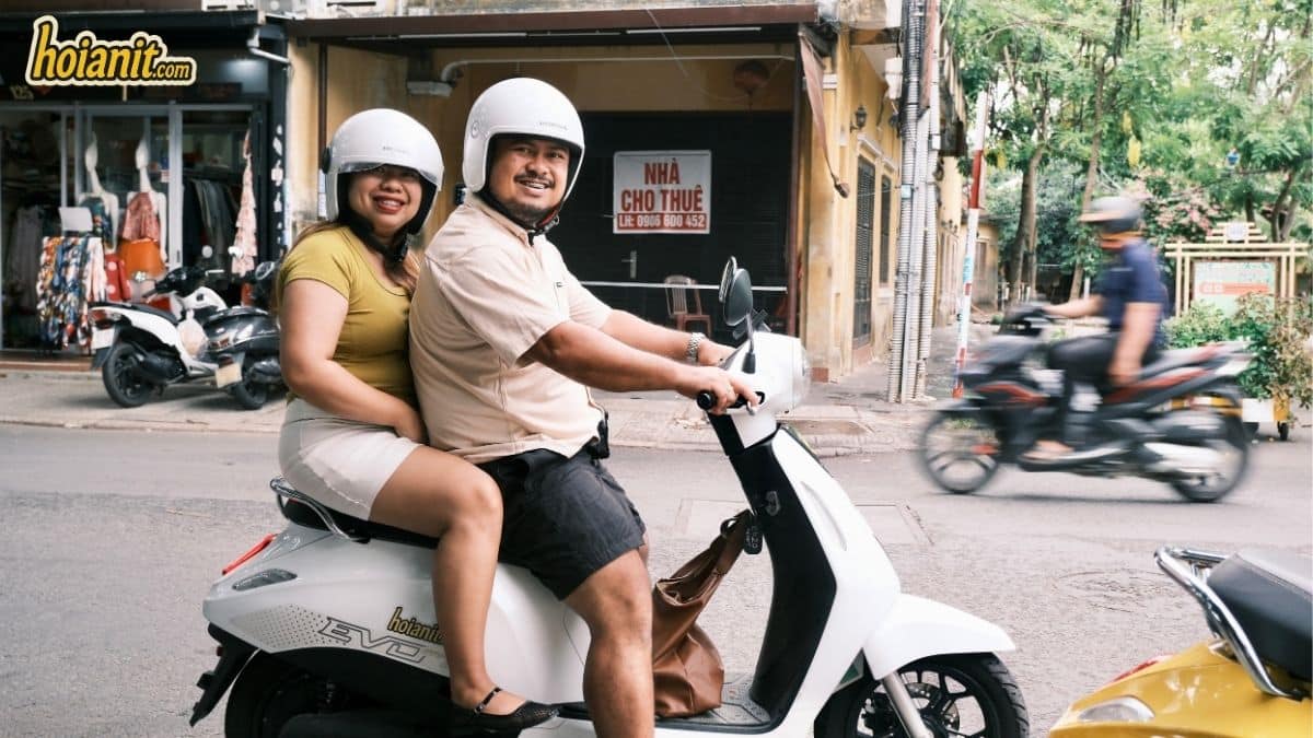 Couple riding a white EVO electric scooter rented in Hoi An
