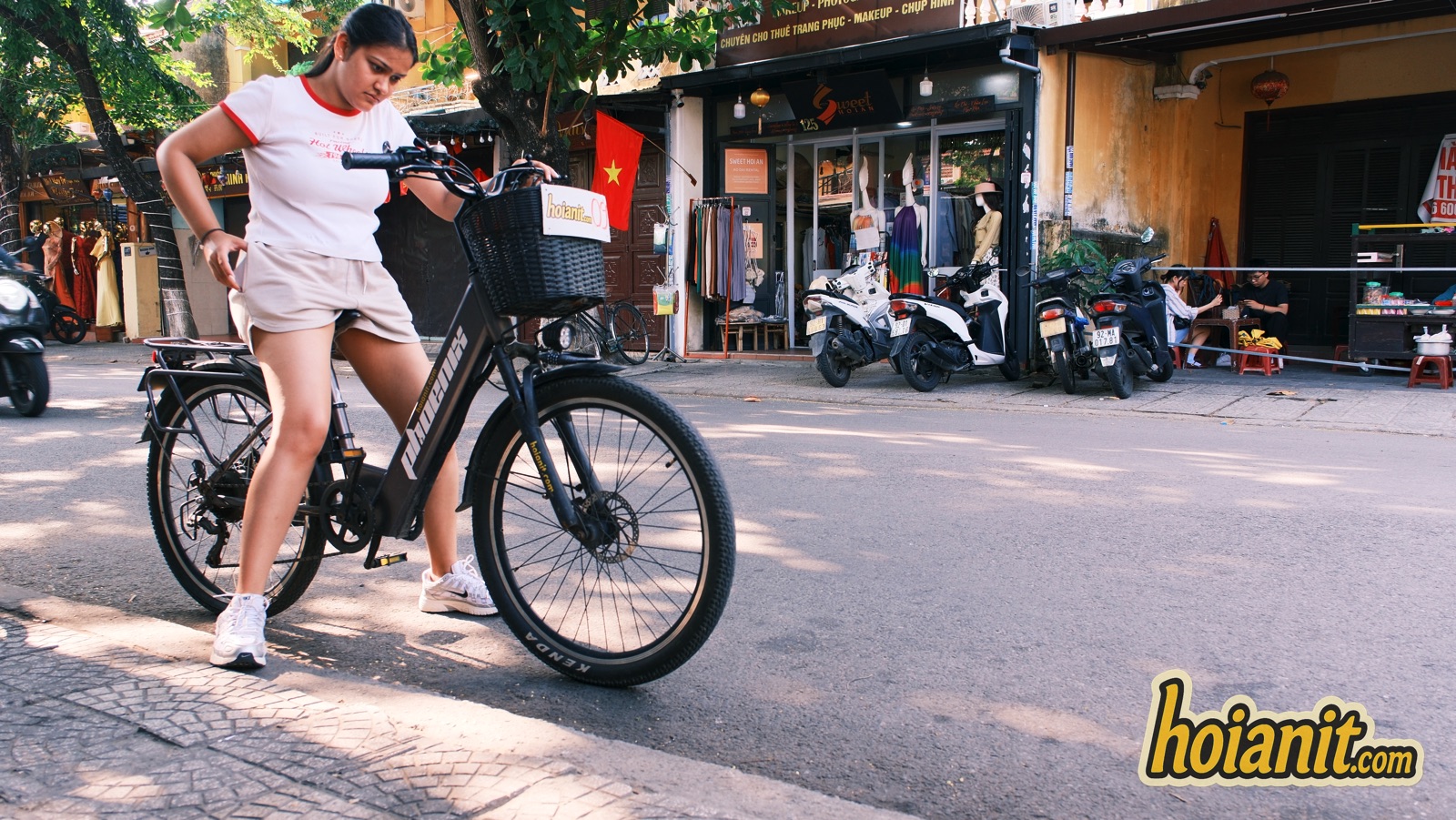 bike rental hoi an7 2 Аренда электровелосипеда в Хойане — девушка на электровелосипеде с корзиной на улице старого города