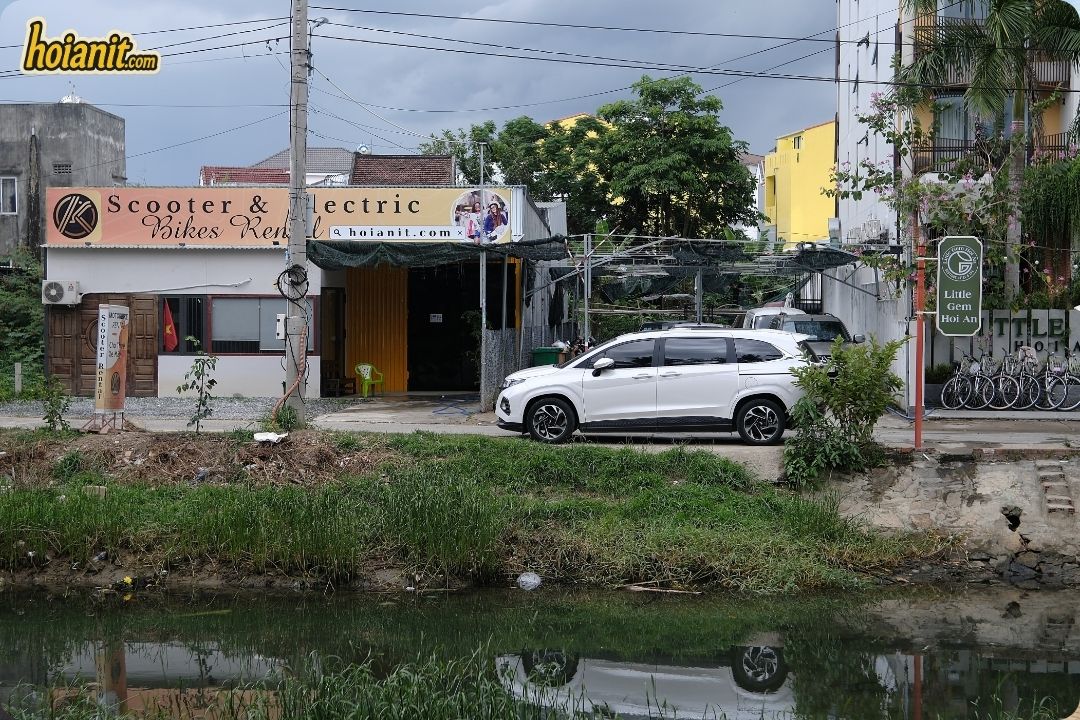 Anh Khoa Scooter and Electric Bikes Rental shop front at 84 Phan Chau Trinh Hoi An seen from across the water
