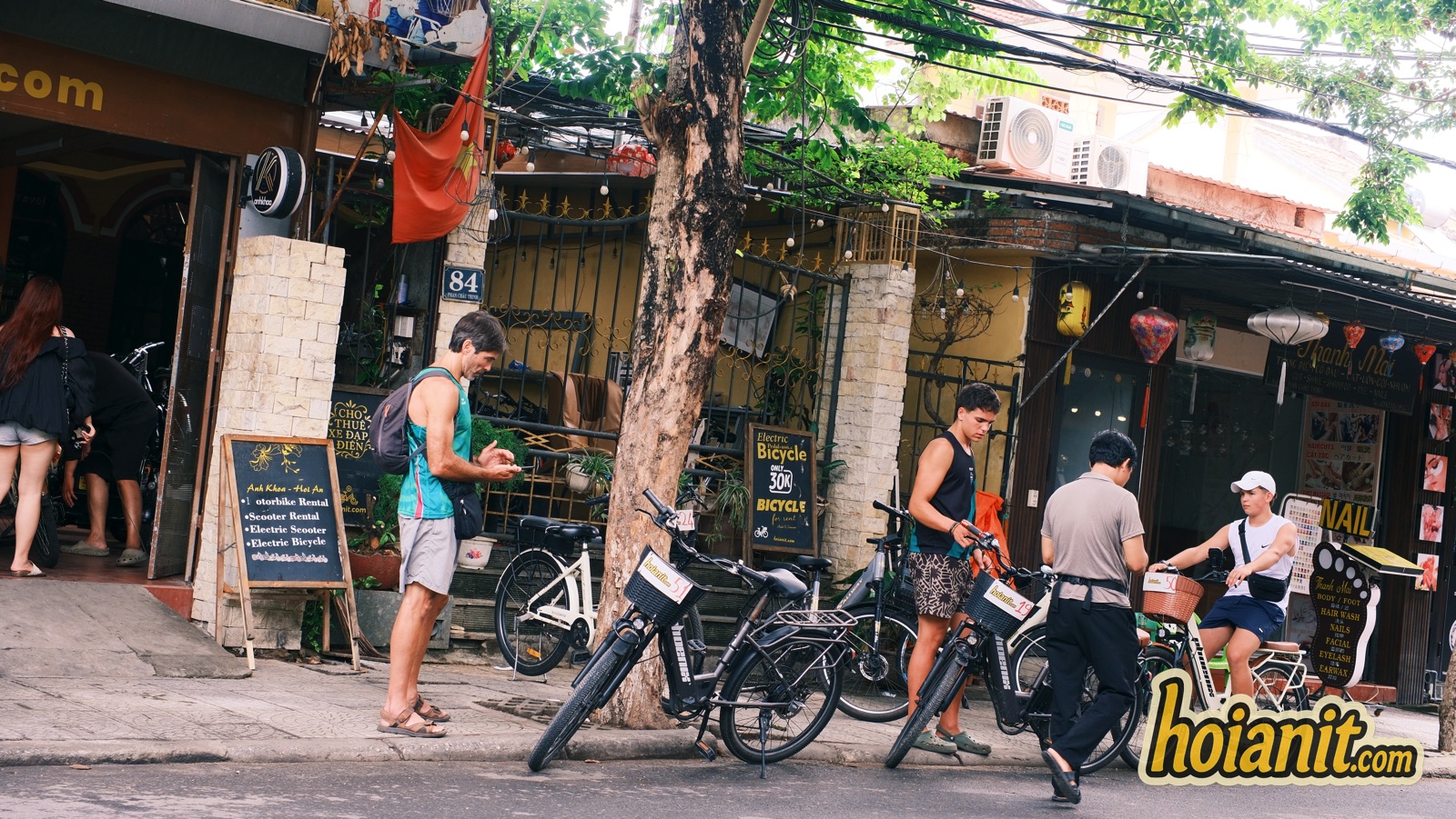 Customers collecting bicycles and electric bikes outside Anh Khoa Hoi An motorbike rental at number 84