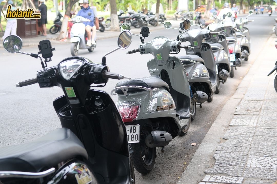 Row of automatic scooters with phone holders ready for scooter rental in Hoi An