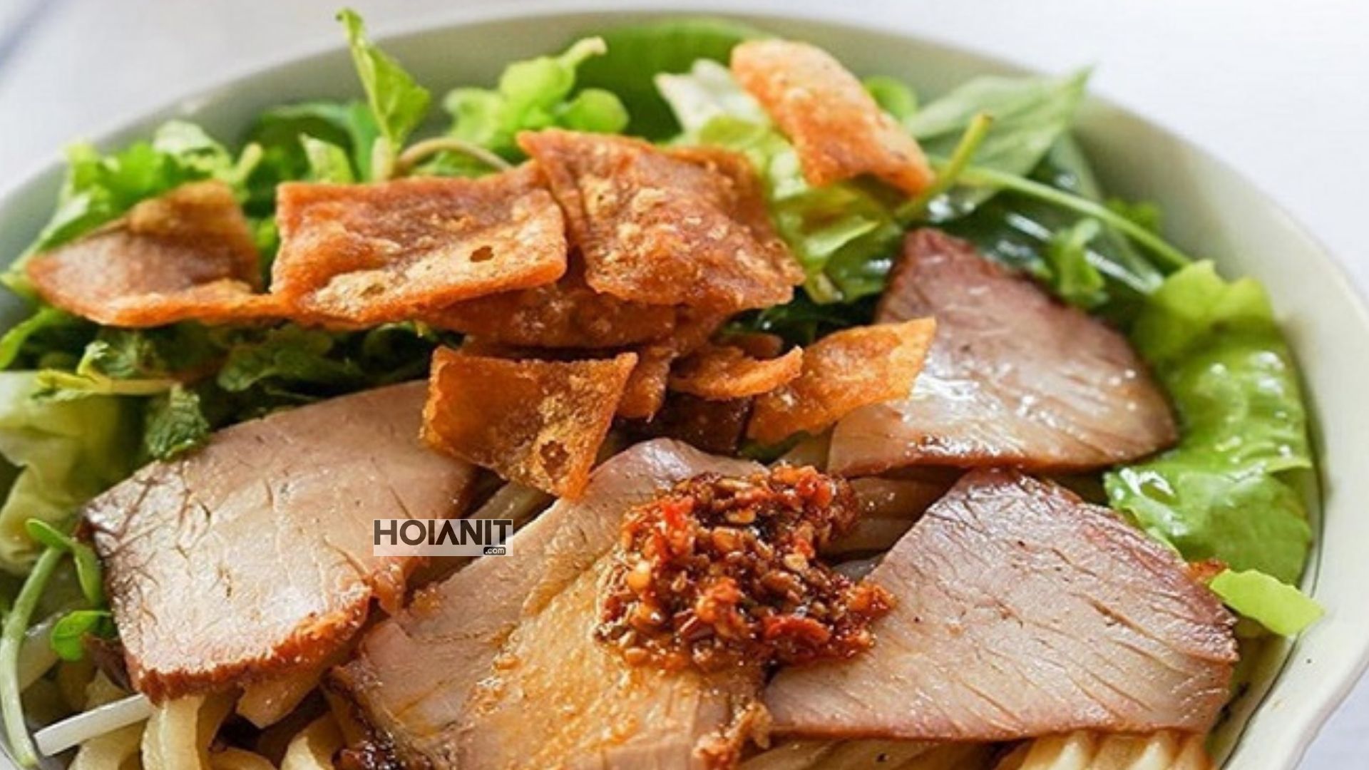 Cao lau at Ba Be in Hoi An market with sliced pork and crisp fried squares