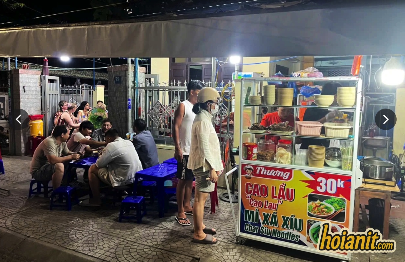 Cao Lau Thuong street cart at 79 Tran Cao Van, cao lau Hoi An for 30,000 dong, with diners on blue plastic stools