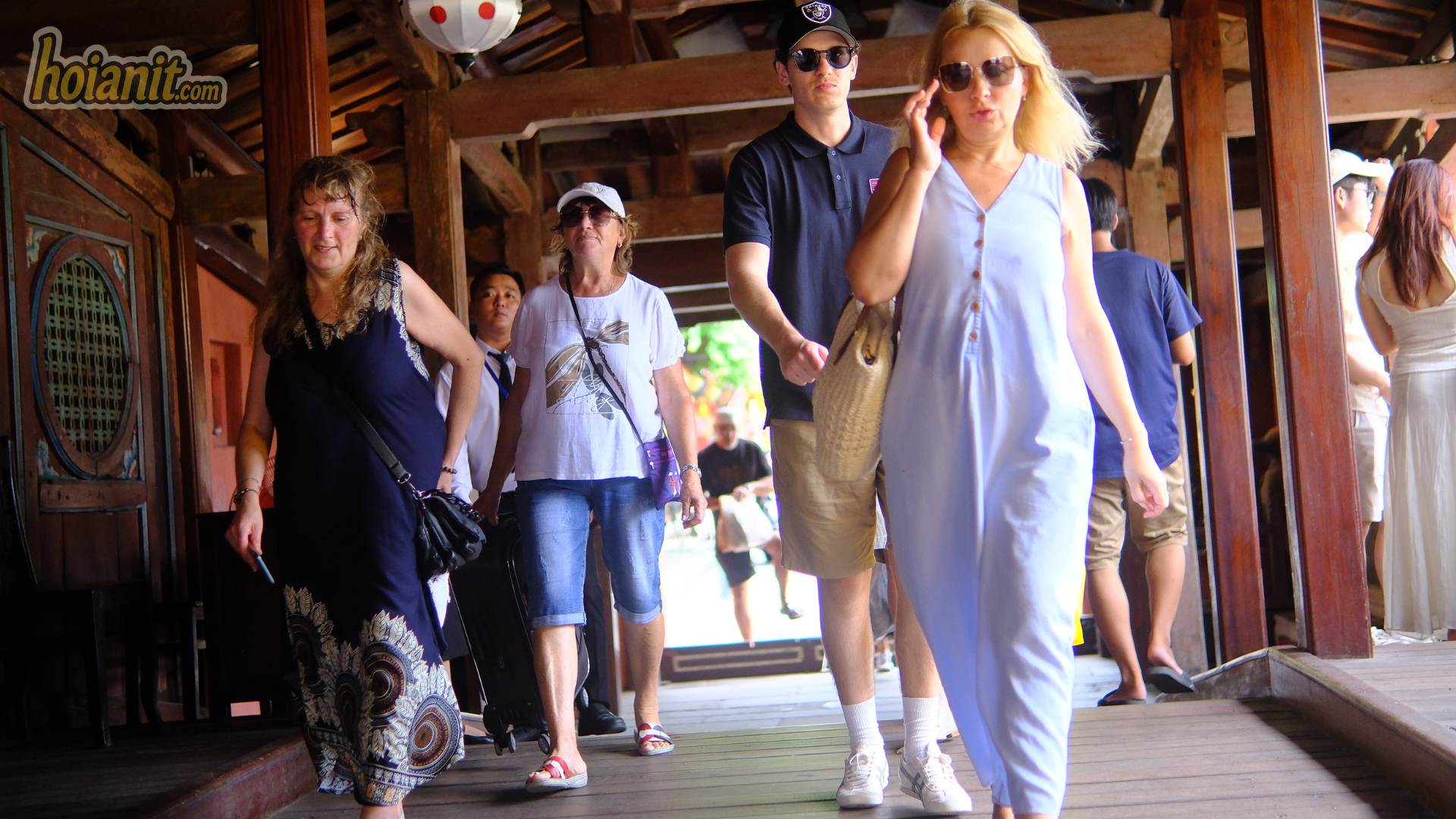 Visitors walking through the Japanese Bridge in Hoi An