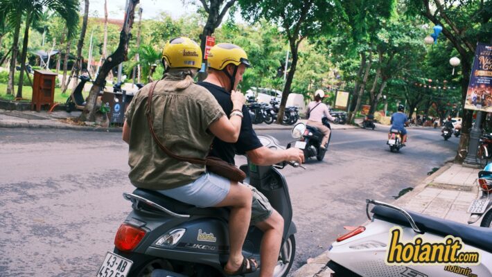 Couple riding scooter Hoi An rental helmets