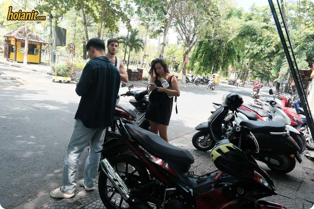 Anh Khoa staff going through a bike with two guests on a Hoi An street