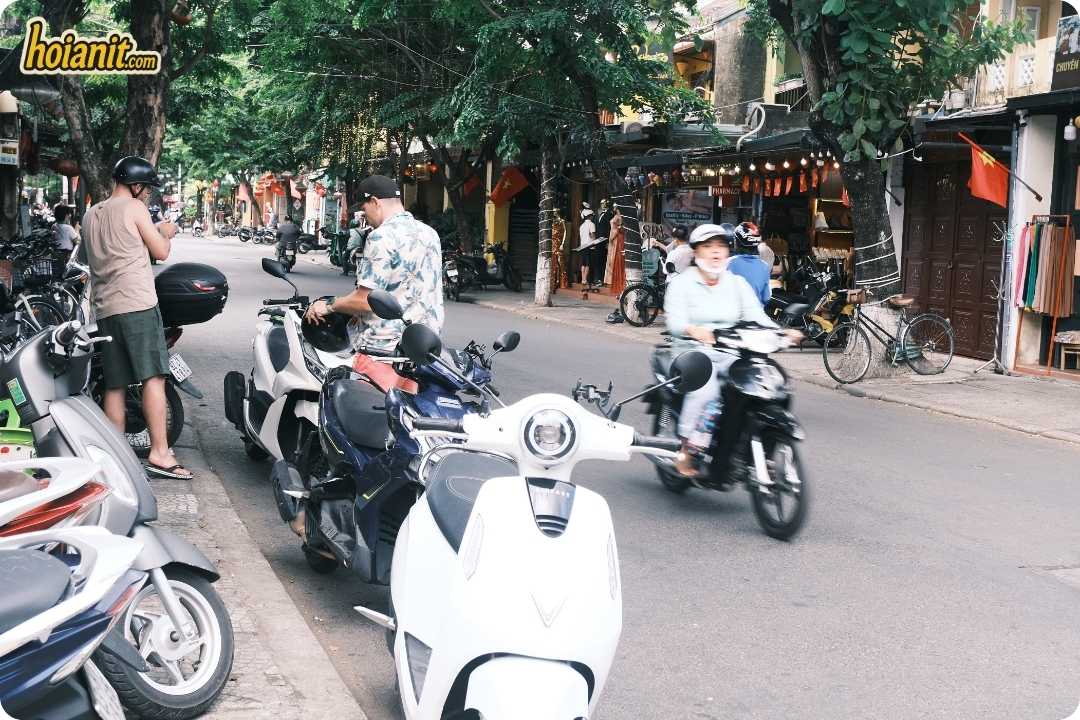 Scooters parked along a shop street near the Hoi An pedestrian zone