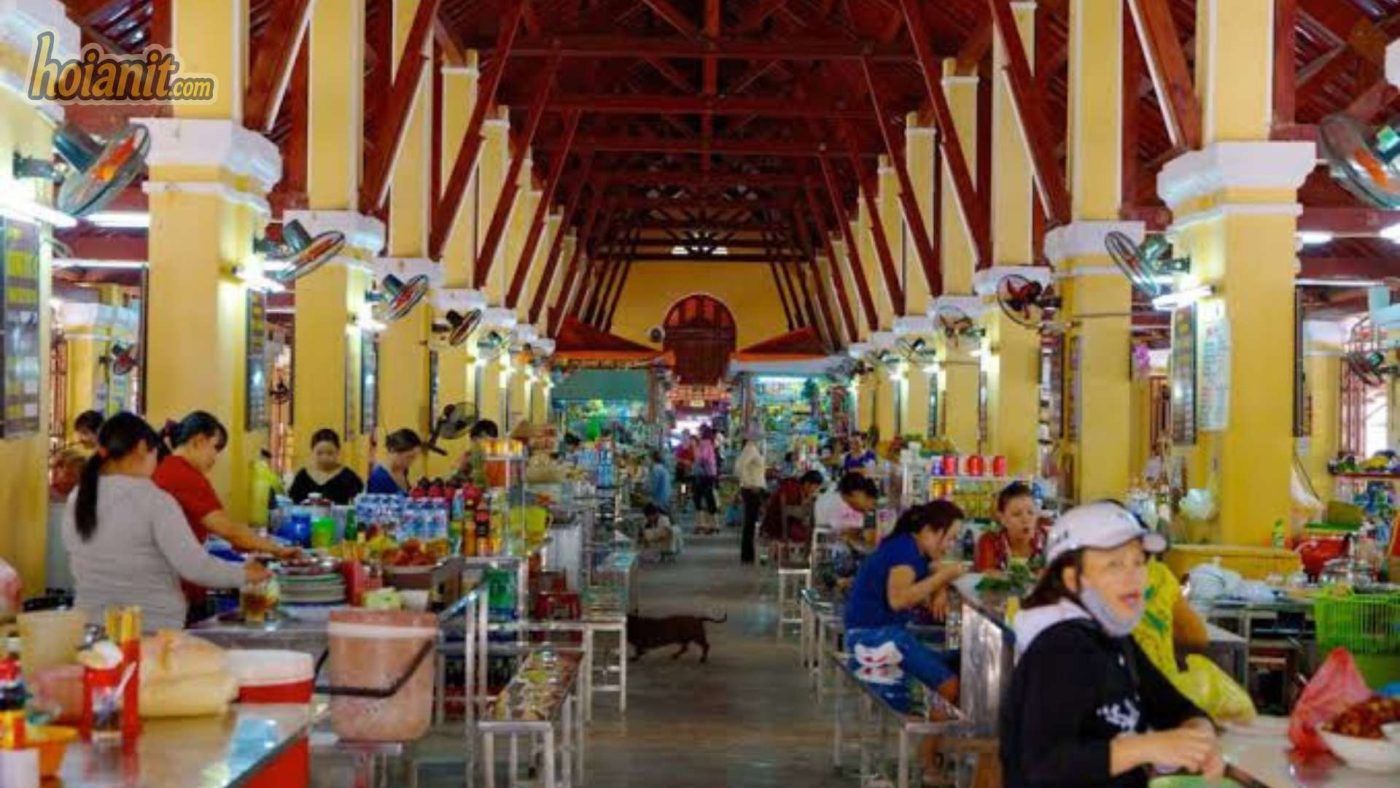 Vendors selling fresh vegetables and seafood at Hoi An Central Market early morning.
