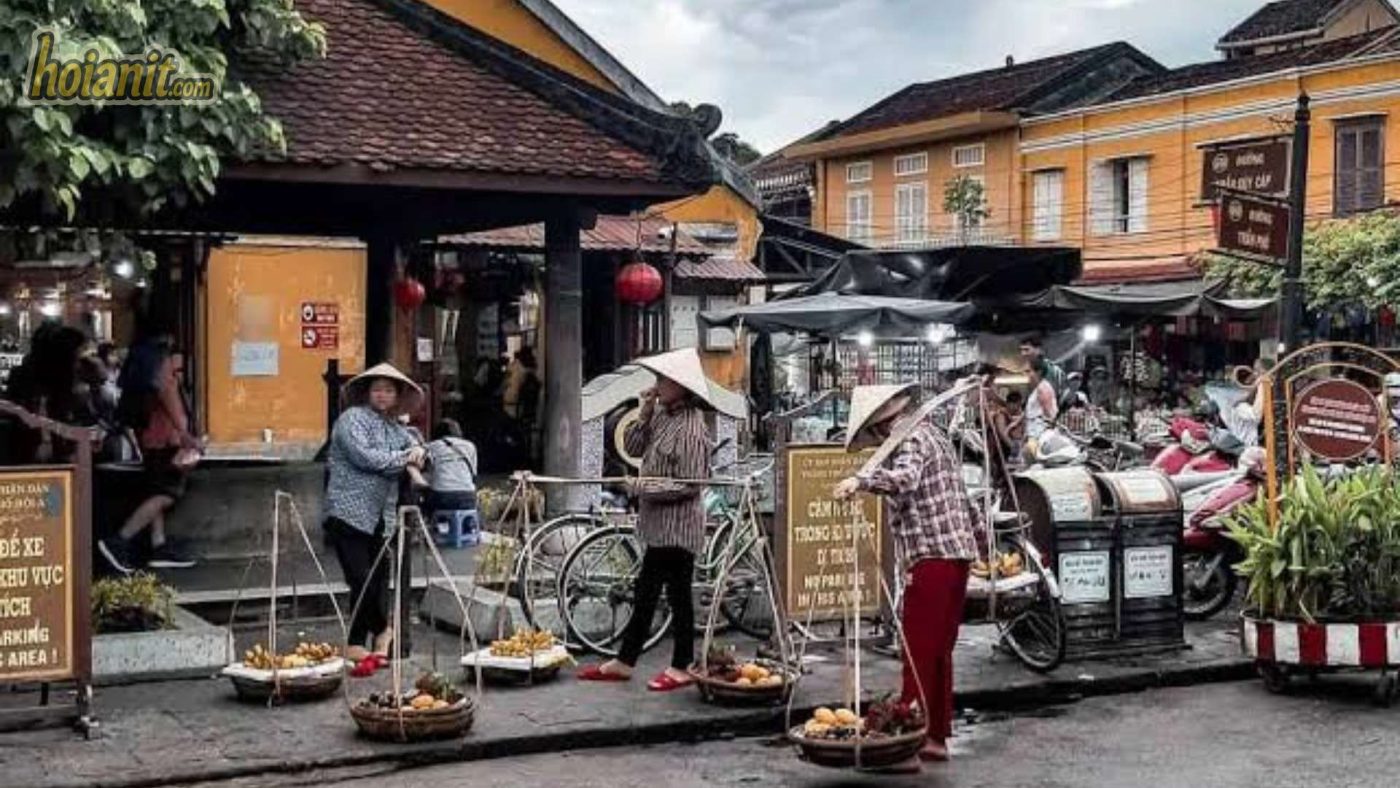 Aerial view of Hoi An Market with yellow ancient roofs and Thu Bon River nearby.