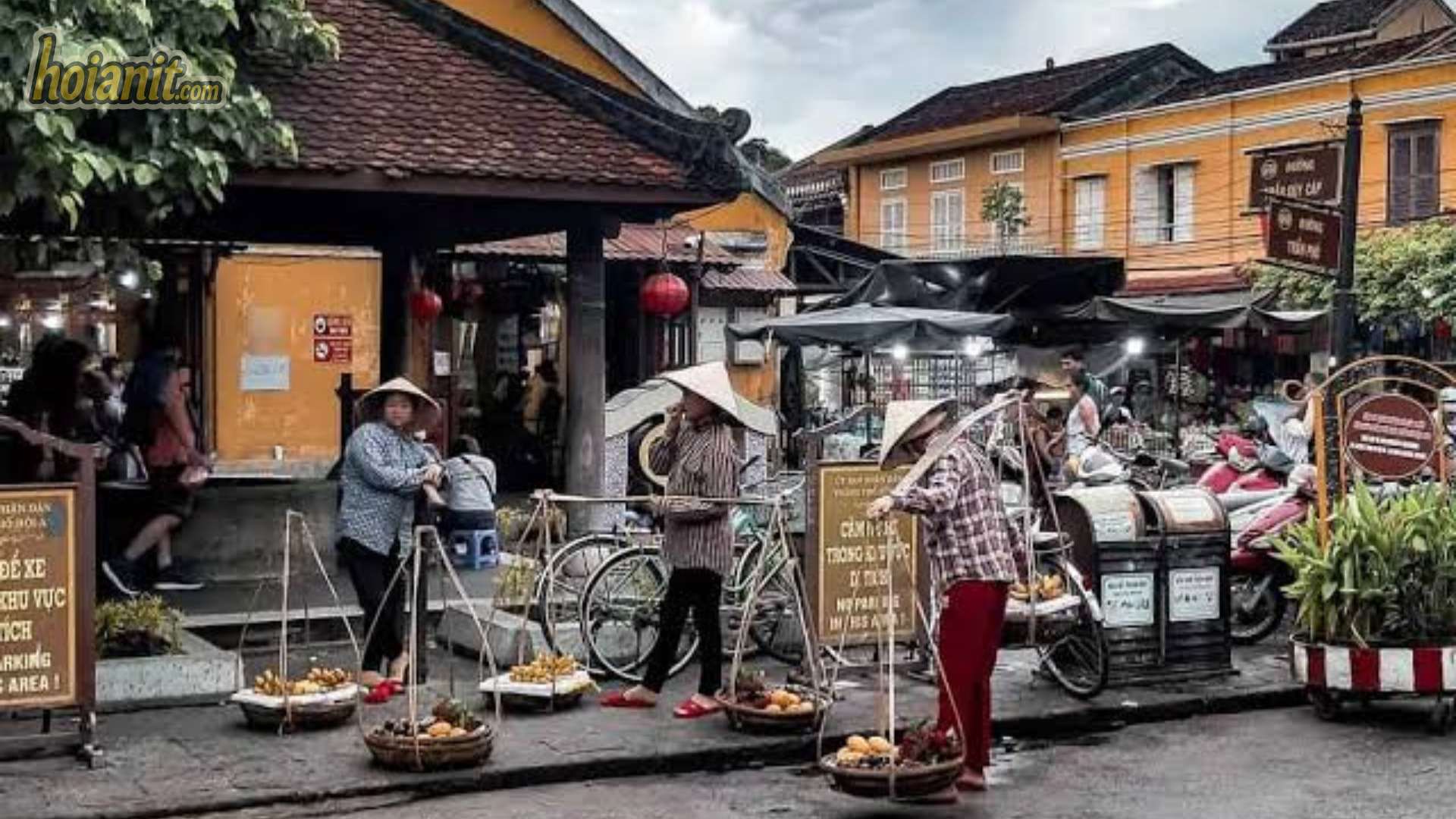 Gánh hàng rong và xe đạp bên ngoài khu chợ buổi sáng
