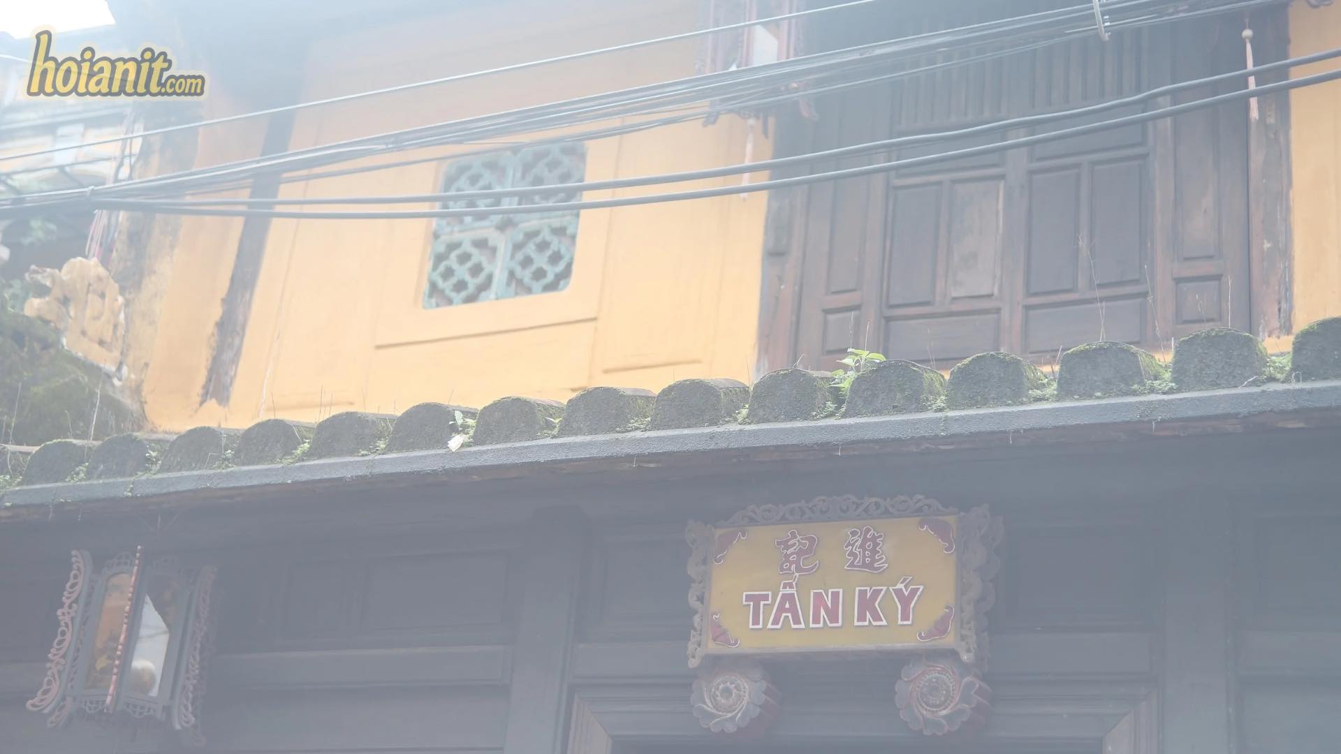 Mặt tiền nhà cổ Tấn Ký Hội An với tường vàng, cửa gỗ và bảng hiệu Tấn Ký