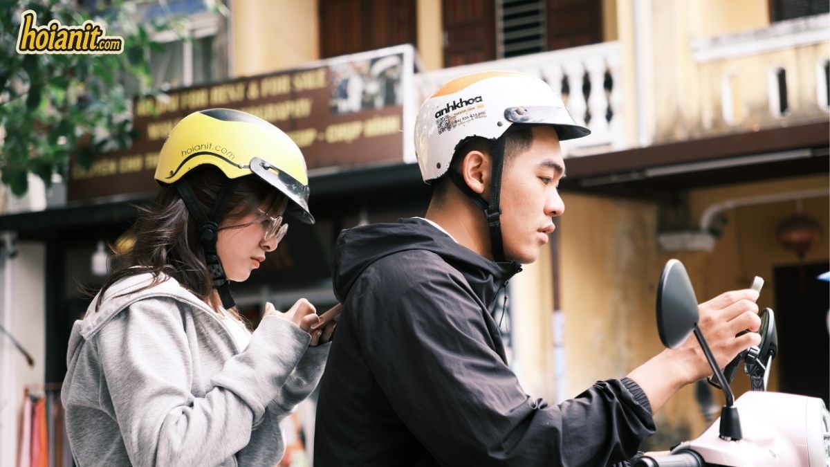 Paar mit Helmen von hoianit.com auf einem Roller in der Altstadt von Hoi An