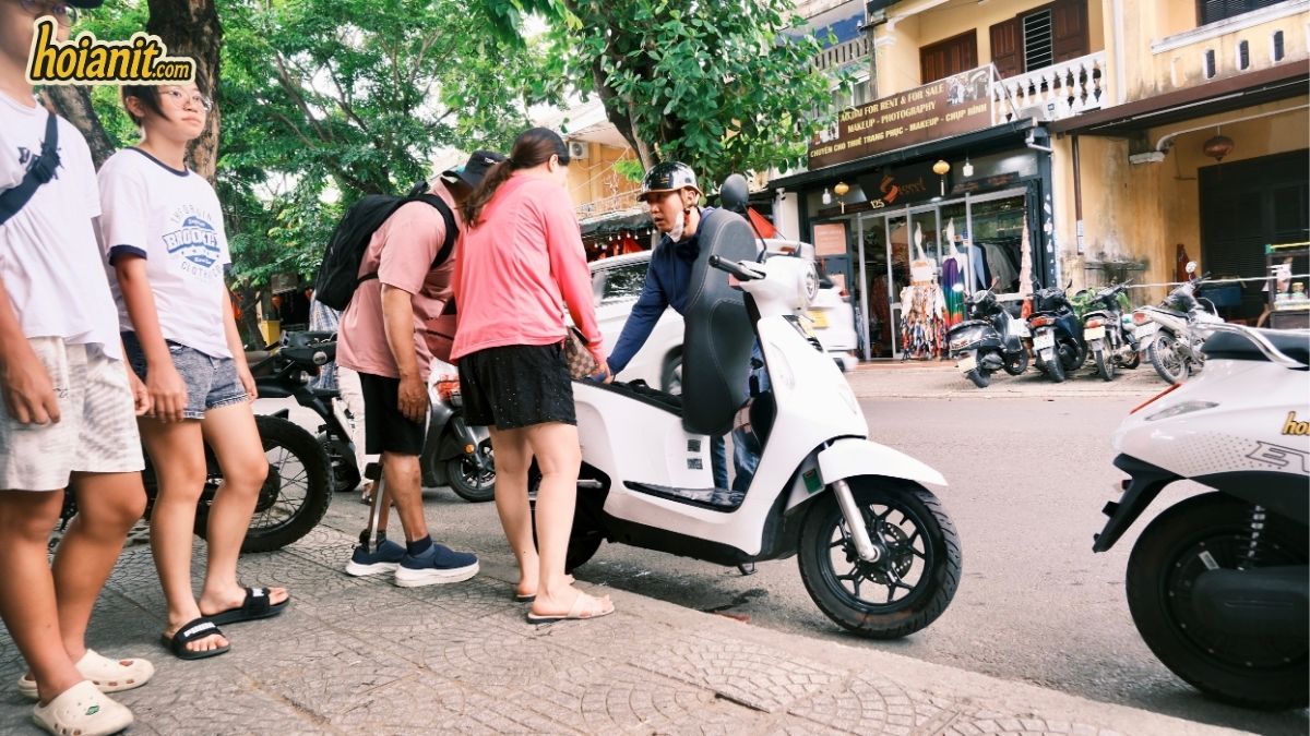 Anh Khoa Mitarbeiter übergibt einen E-Scooter an Kunden in Hoi An
