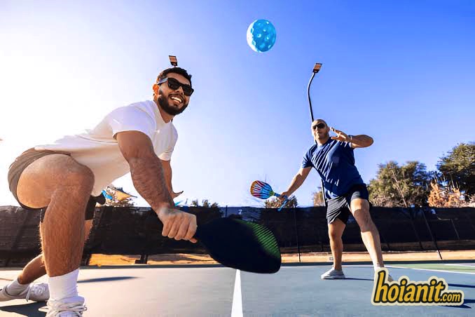 Two players in a doubles pickleball rally on an outdoor court