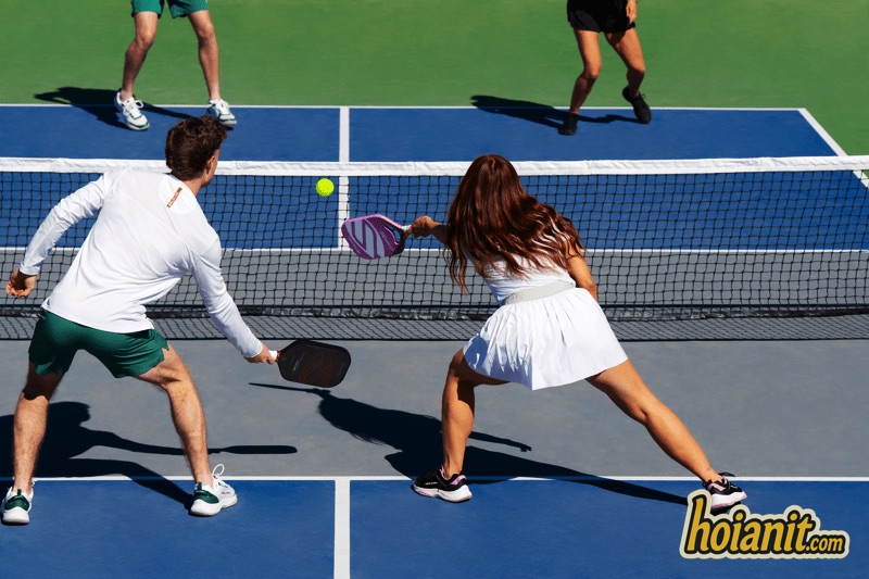 Mixed doubles pickleball players at the net