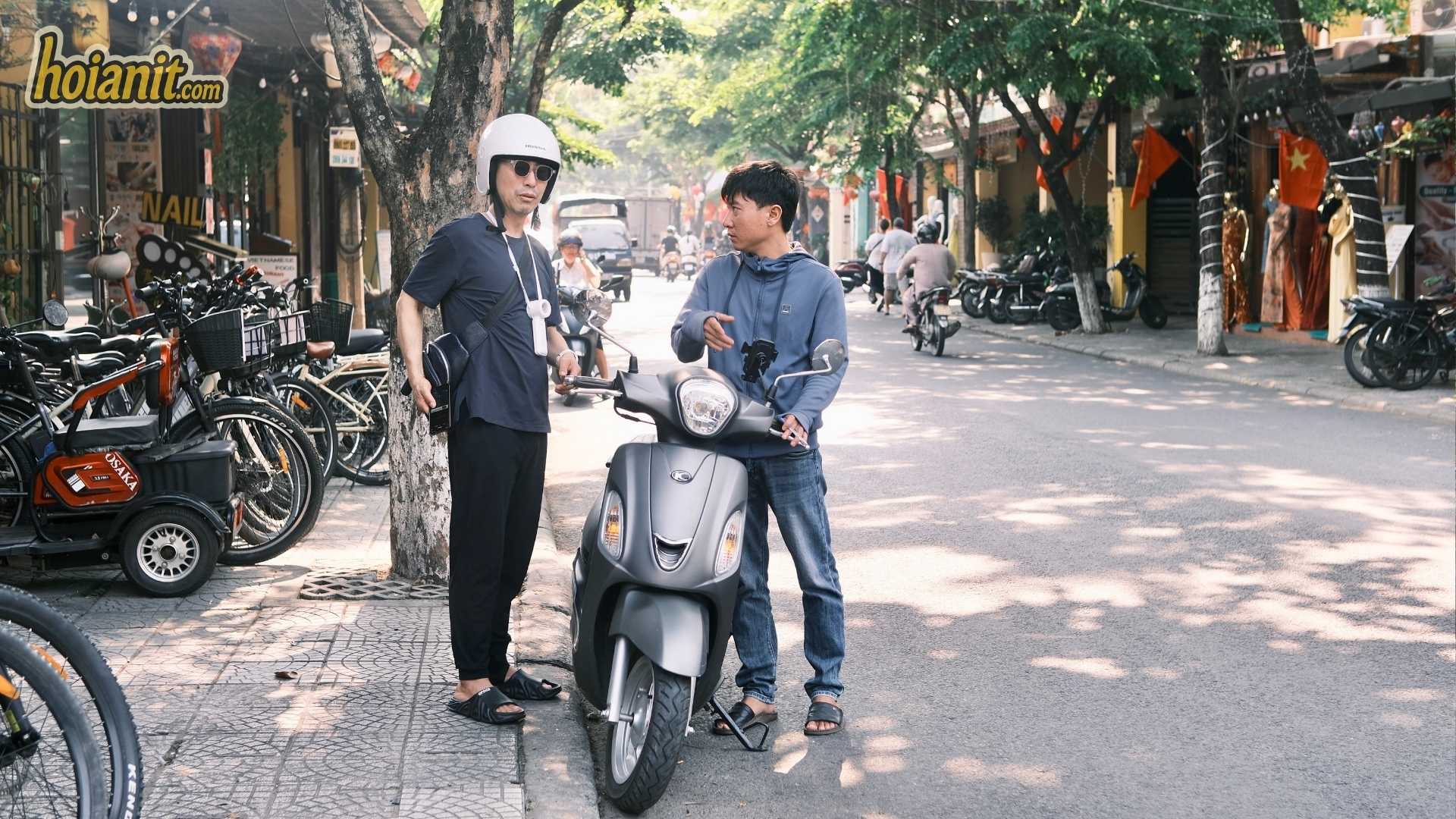 Anh Khoa staff checking a grey VinFast Evo electric scooter with a guest before a ride
