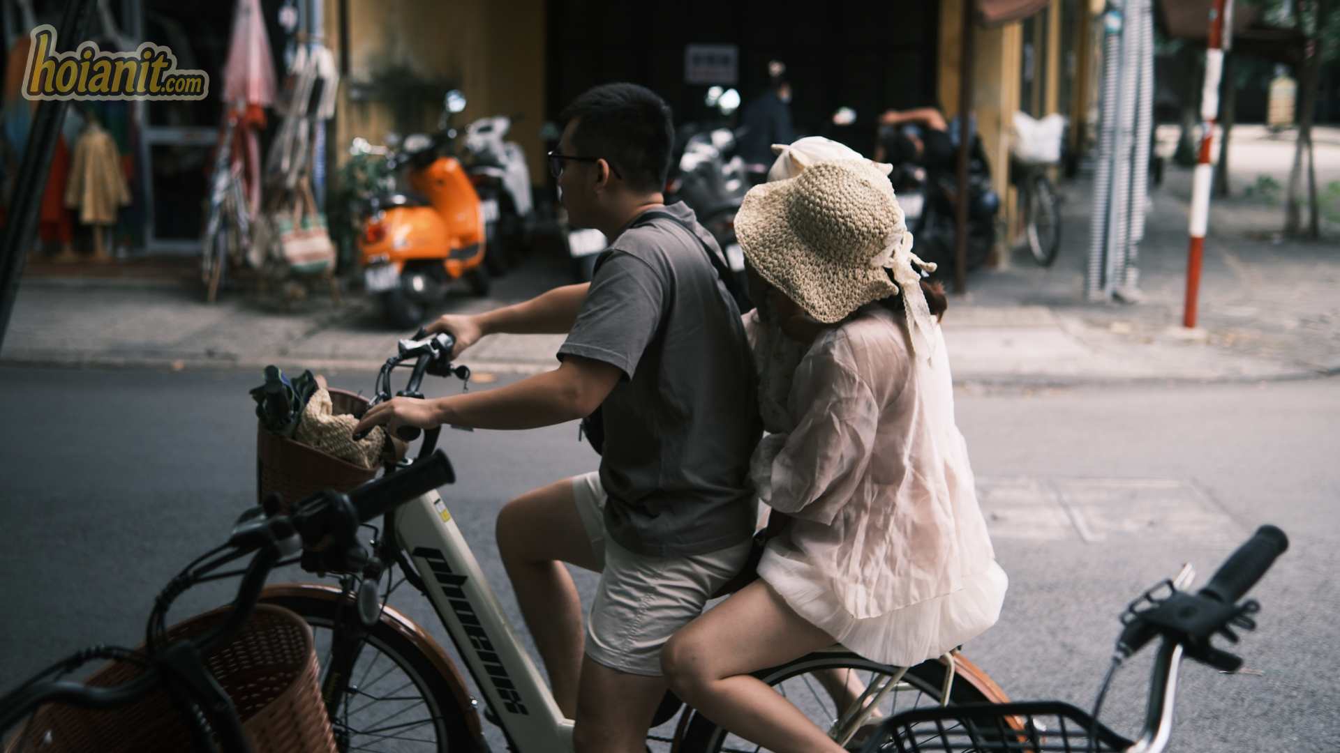 Hai khách chở nhau bằng xe đạp điện thuê ở Hội An