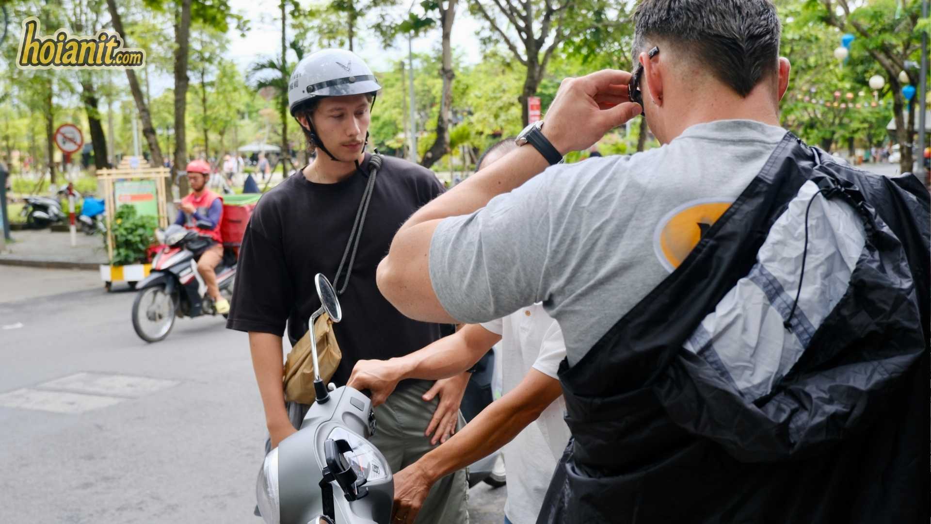 thue xe may hoi an co can bang lai khong2 Staff fastening a helmet for a tourist before handing over a no-license bike in Hoi An