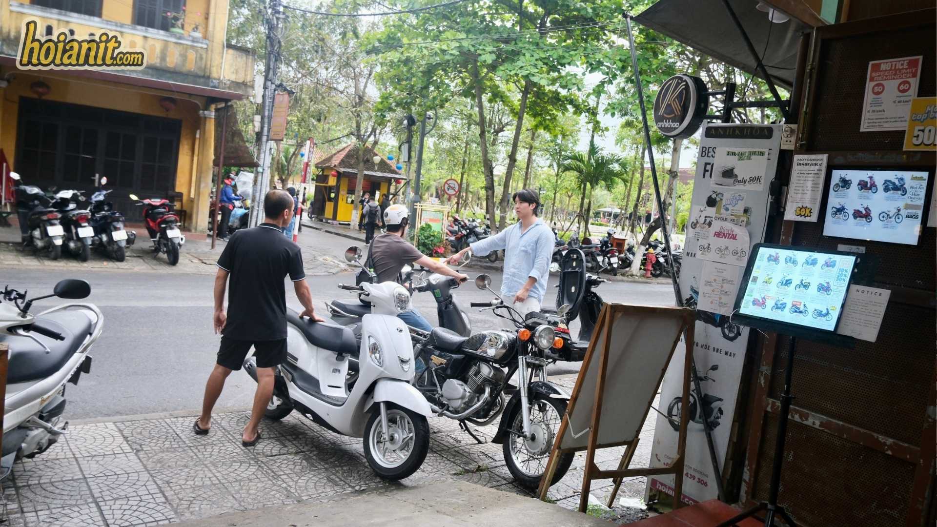 thue xe may hoi an di hai van2 Nhân viên Anh Khoa bàn giao xe tay ga trắng cho khách trước cửa hàng ở Hội An